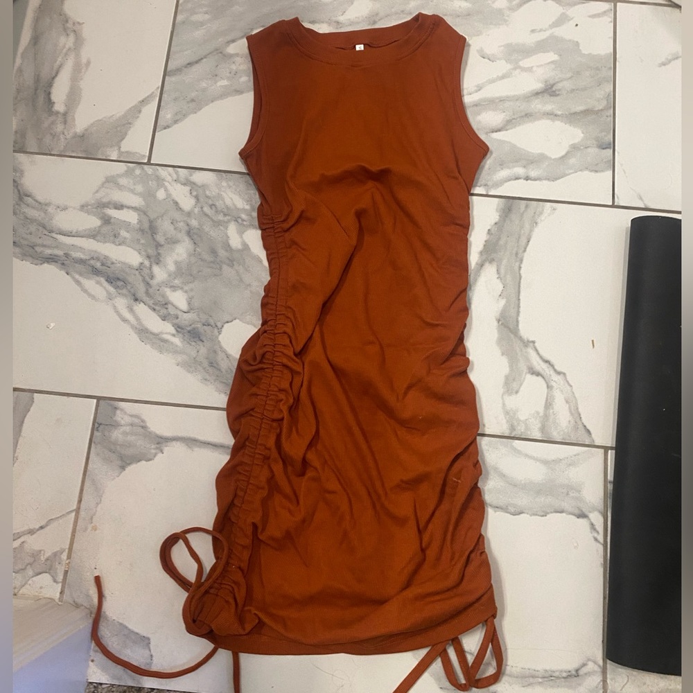 Dark orange/brownish tight fitting dress with ties at bottom